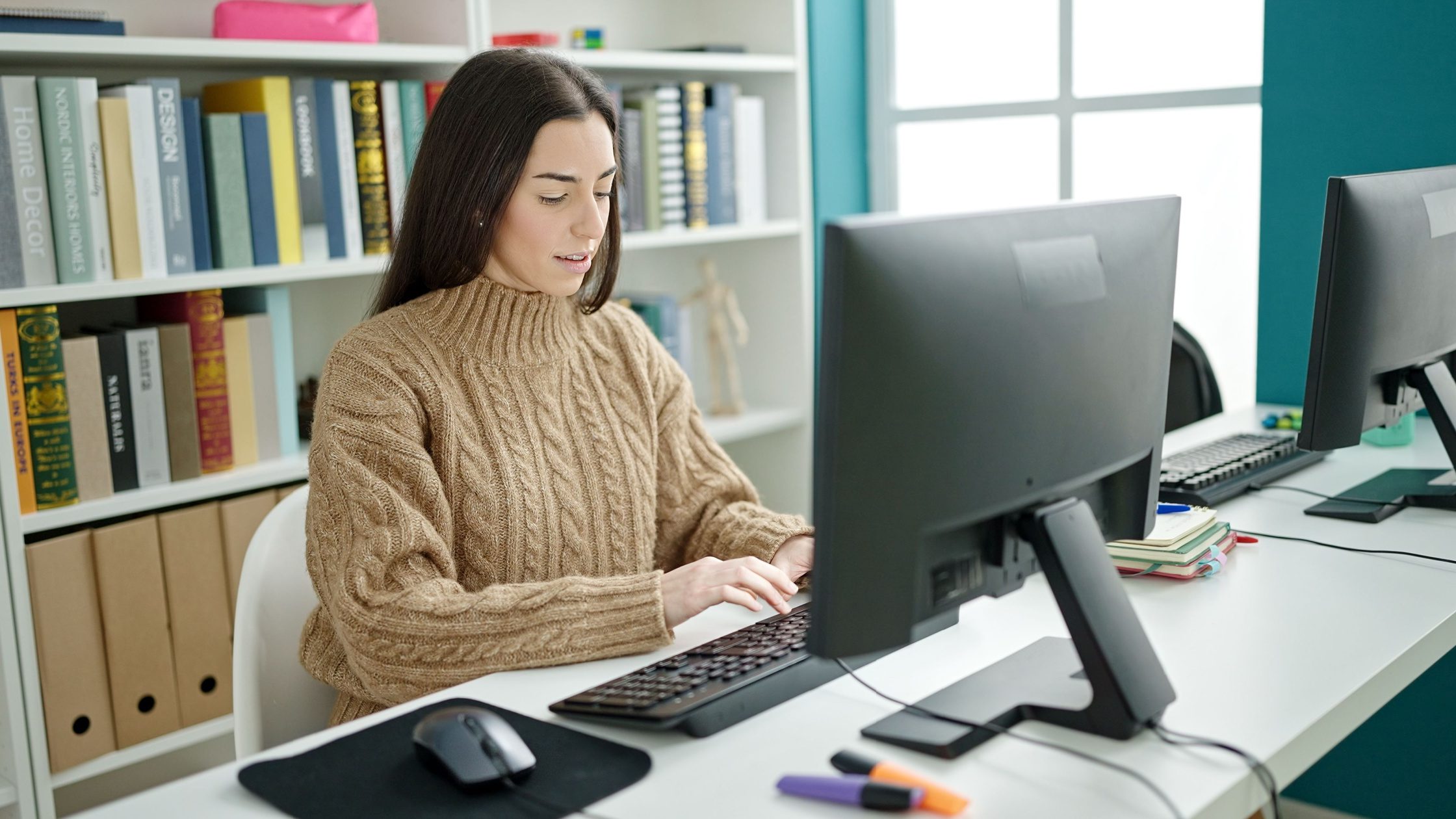 A medical student taking a USMLE Step 2 CK practice test in a library un front of a computer.
